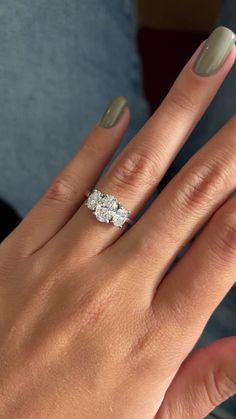 a woman's hand with a ring on her finger and two diamonds in the middle