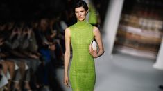 a model walks down the runway in a lime green dress