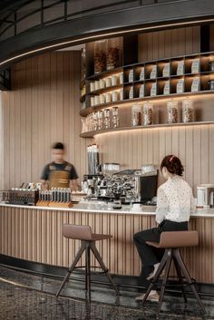 two people sitting at a counter in a coffee shop