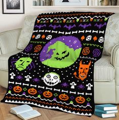 a couch with a blanket on top of it in the shape of a pumpkin and ghost