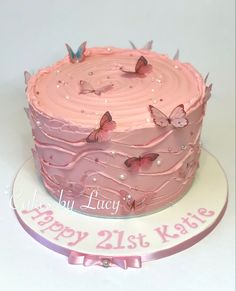 a birthday cake with pink frosting and butterflies on it