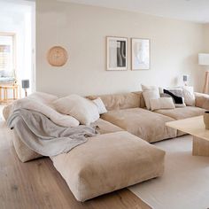 a living room filled with lots of furniture and decor on top of a hard wood floor