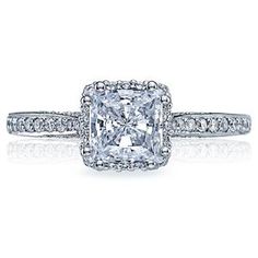 an engagement ring with a princess cut diamond in the center and pave set shoulders