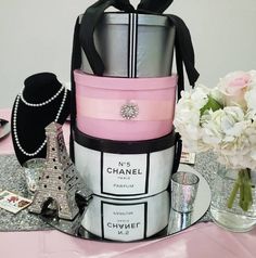 a stack of chanel purses sitting on top of a table next to flowers