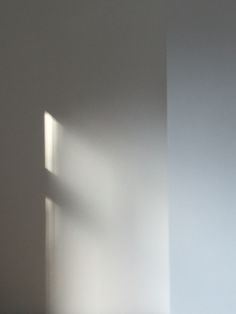 the corner of a room with a window and light coming in from it's side