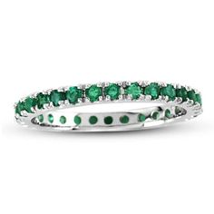 a white gold ring with emerald stones