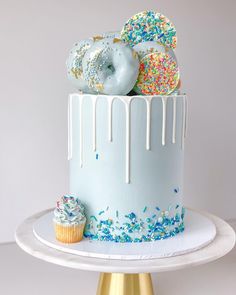 a blue cake with sprinkles and donuts on top