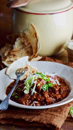 a white bowl filled with chili and bread