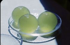 three green eggs in a glass bowl on a table