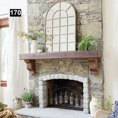 a stone fireplace with potted plants on top and an arched window over the mantle