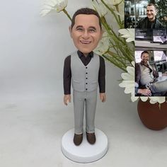 a bobble head is shown next to a vase with flowers and a photo of a man