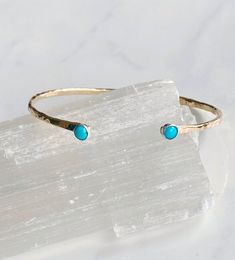 This gorgeous cuff is stunning worn on its own or can be mixed with other bangles and bracelets. It features two genuine sleeping beauty turquoise 4mm cabochons bezel set into a sterling silver setting.  The cuff is hand forged from heavy gauge 14kt goldfill wire  and hammered with the dappled texture to catch the light.  It sits comfortably on the wrist and is adjustable to fit most any wrist. Adjustable Hammered Turquoise Jewelry, Bangles And Bracelets, Turquoise Stones, Sleeping Beauty Turquoise, Timeless Accessories, 14kt Gold, Hand Forged, Turquoise Stone, Beautiful Bracelet