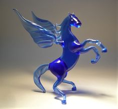 a glass figurine of a blue horse with wings on its hind legs and tail