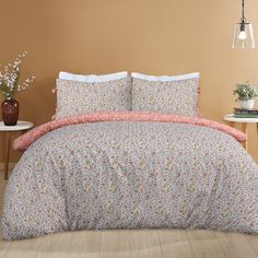 a bed with a floral comforter and matching pillowcases in a brown room