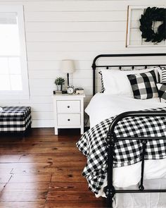 a black and white checkered bedspread on a bed in a room with wood floors