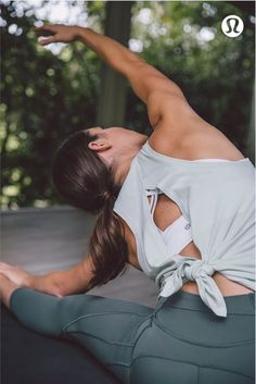 a woman is doing yoga on the ground