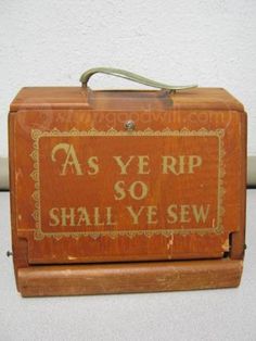 an old fashioned wooden box that says as ye rip, so shall ye sew