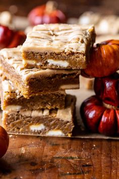 a stack of brownies sitting on top of a wooden cutting board next to apples