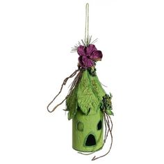 a green birdhouse with purple flowers on it's roof hanging from a string