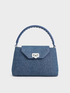 This product is made with at least 20% sustainable materials by weight. CHARLES & KEITH uses recycled, degradable, organic, and water-based materials in our eco-conscious collection. This iteration of the Arwen bag proves that denim really is for every occasion. Details like a braided top-handle and denim finish relaxes the top-handle style, imbuing it with a cool-girl appeal that can be adapted for casual and formal occasions alike. With the addition of a push-lock closure that doubles as a metallic accent, the bag exudes effortless charm -- carry it by hand for an elevated look, or convert it into a crossbody bag to dress it down. Brand Collaboration, Charles Keith, Braided Strap, Strap Tops, Eco Conscious, Sustainable Materials, Handle Bag, Metallic Accents, Kids Gifts