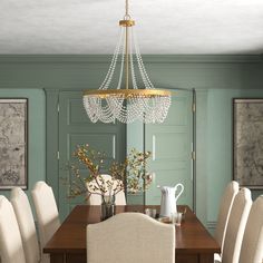 a chandelier hangs from the ceiling above a dining room table with white chairs