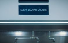 there is a sign that says every second counts on the wall above the urinals