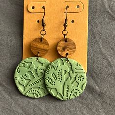 pair of green earrings with wooden disc and floral design