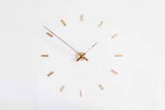 a clock made out of wood sticks on a white surface with the numbers six to twelve