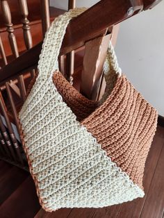 a crocheted bag hanging from the side of a wooden chair next to stairs