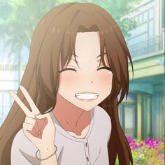 a girl with long brown hair holding up her peace sign