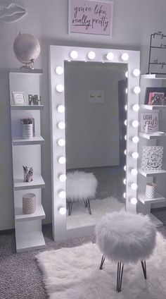 a room with a mirror, stool and lights on it's sides in front of a shelf