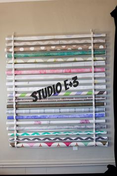 a wall hanging made out of strips of colored paper with the word studio f3 on it