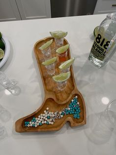 a wooden tray with glasses, limes and mints in it on a table