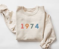 a white sweatshirt with the number 1974 printed on it