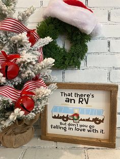 a christmas tree with a red and white bow on it next to a sign that says, that there's an rv but don't you falling in love with it