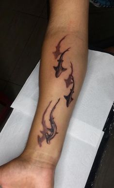 a man with a tattoo on his arm that has three dolphins in the middle of it