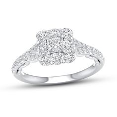 a white gold ring with diamonds on the shoulders and an oval shaped center stone in the middle