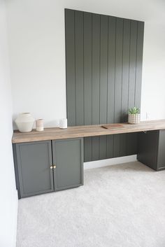 an empty room with some gray cabinets and white carpet on the floor in front of it