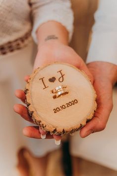 a person holding a piece of wood with the word i love you written on it