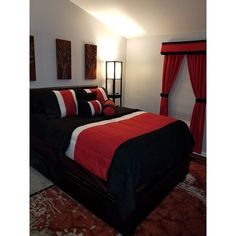 a bed with red and black pillows in a bedroom