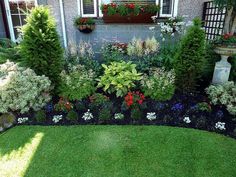 a garden with lots of different types of flowers and plants in the middle of it