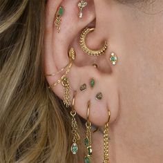 a close up of a person with ear piercings and jewelry on their left side