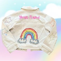 a white jacket with rainbows and clouds on it that says you're name