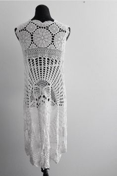 a white crocheted top is hanging on a mannequin's head