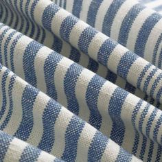 blue and white striped fabric is shown in close up view, with vertical stripes on it