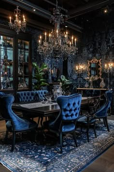 an elegant dining room with blue velvet chairs and chandelier hanging from the ceiling