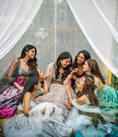 four young women are sitting on the ground and having fun with each other while laughing