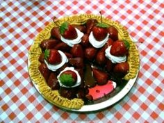 strawberries and whipped cream in a pie on a checkered tablecloth