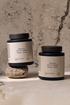 two jars sitting on top of a rock next to each other, one containing different ingredients