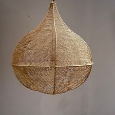 a hanging basket made out of woven material with a wooden hook on the end and two strings attached to it